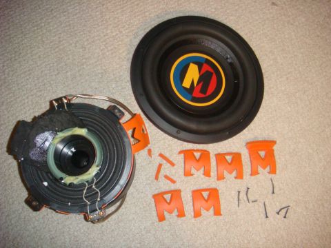 1996 Ford Bronco - Car speaker components laid out on a carpeted surface, showing a damaged speaker and a separate woofer cone.