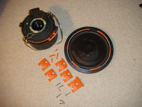 1996 Ford Bronco - Disassembled car speaker components and orange mounting brackets are laid out on a carpeted surface.