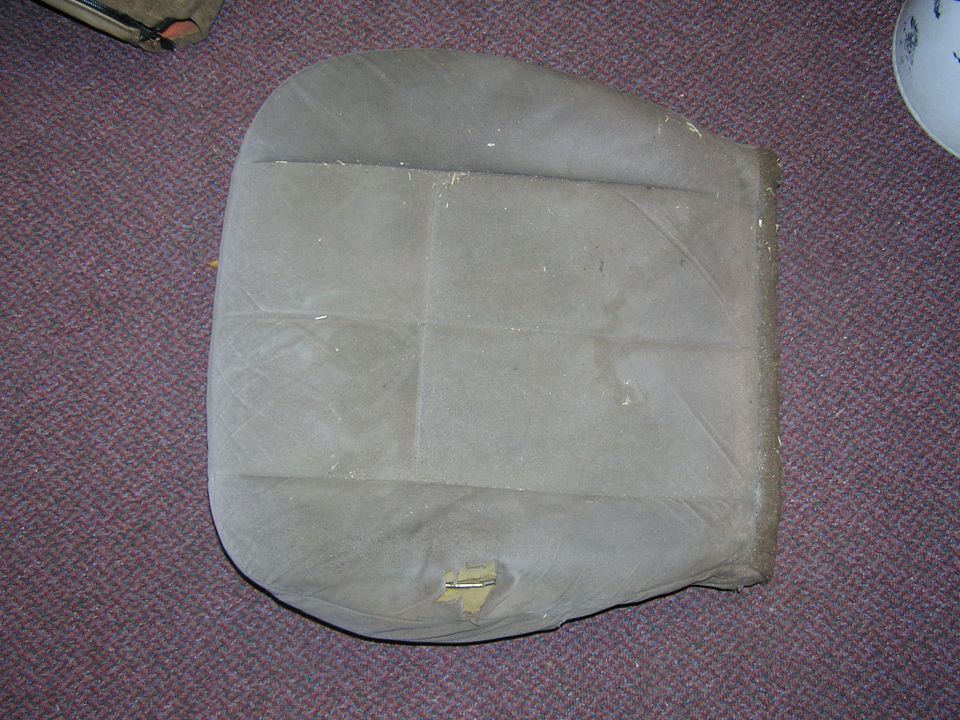 Tan upholstered seat cushion on carpet