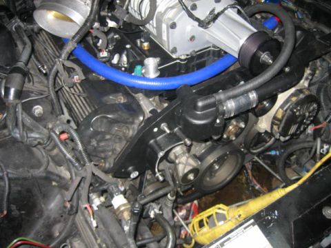 1996 Ford Thunderbird - Close-up view of a modified engine bay a supercharger and various hoses and wiring.