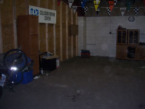 1979 Ford Bronco - Interior of a collision repair center with a prominent sign and various stored items.