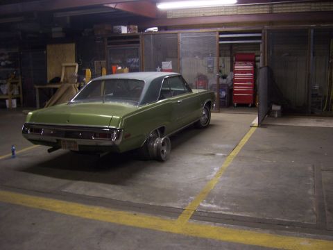 1979 Ford Bronco - Green sedan with custom wheels parked inside a garage.