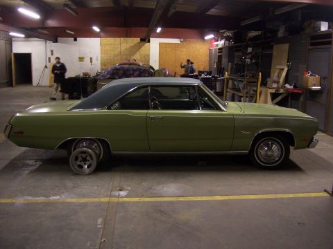 1979 Ford Bronco - A light green coupe with a dark roof sits in a garage, one rear wheel is a different style.