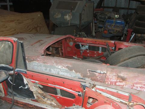1965 Ford Mustang - This red convertible shows significant rust and damage, with its interior and body in a state of disrepair.