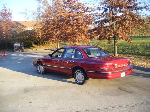 1994 Ford Crown Victoria - Rear three-quarter view of a red 1994 Ford Crown Victoria sedan parked outdoors.