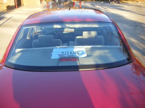 1994 Ford Crown Victoria - Rear view of a red sedan's interior, with a towel bearing the word "TITANS" visible on the back window.