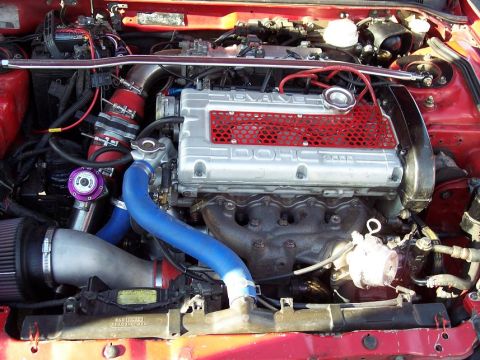 1991 Mitsubishi Eclipse - The engine bay of a 1991 Mitsubishi Eclipse shows a modified 4G63 engine with a blow-off valve and intercooler piping.