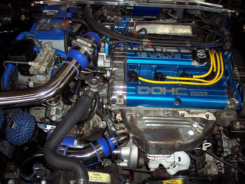 Engine bay with blue 16-valve DOHC 4G63 engine cover, chrome piping, and blue air filters