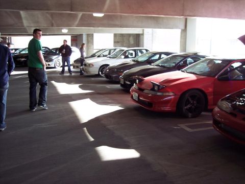 1991 Mitsubishi Eclipse - Several cars, including a red 1991 Mitsubishi Eclipse, are parked in a multi-level garage.