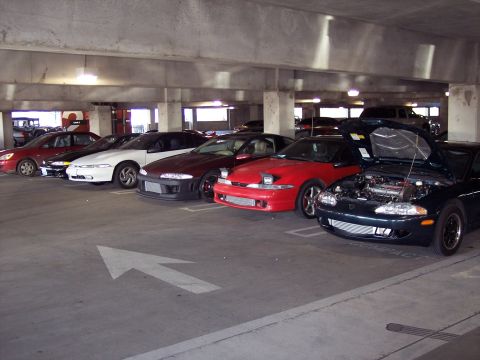 1991 Mitsubishi Eclipse - A collection of Mitsubishi Eclipses are parked in a garage, with one vehicle displaying its engine.