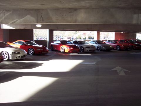 1991 Mitsubishi Eclipse - Multiple Mitsubishi Eclipses are parked in a garage, bathed in sunlight and shadow.