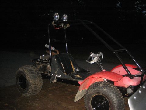 1995 Ford Bronco - A red and black custom-built go-kart with a roll cage and dual headlights is shown outdoors at night.
