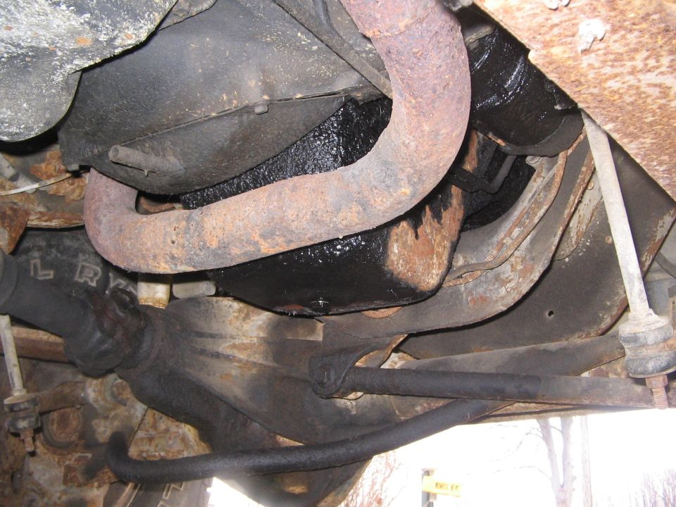 Rusty undercarriage with exhaust and driveline components