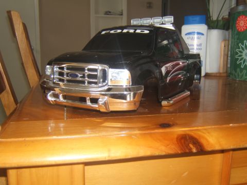 1988 Ford Bronco - A black Ford F-350 model truck with chrome accents sits on a wooden table. The model features a detailed front grille, headlights, and a Fo…