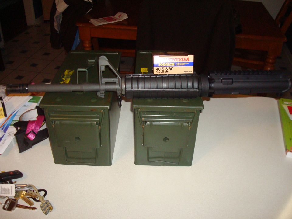 Rifle barrel and receiver on ammo cans with box of ammunition