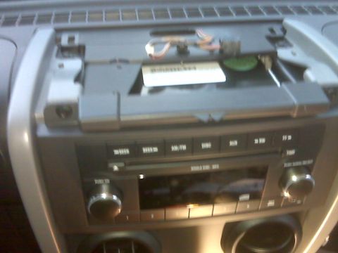 2008 Jeep Wrangler - A close-up view of the center console of a Jeep Wrangler, showing the car stereo and climate controls. The stereo faceplate is partially re…