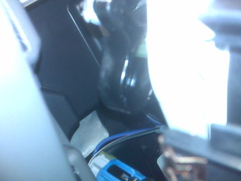 2008 Jeep Wrangler - A close-up view of wiring and a blue connector visible inside a vehicle's dashboard area. The lighting is bright and washes out some detail…