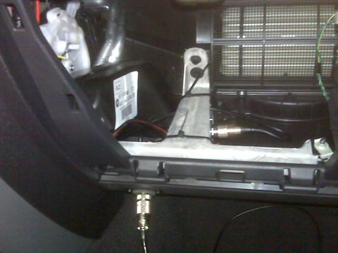 2008 Jeep Wrangler - A close-up view of the interior of a vehicle, showing wiring and a metal bracket. A black plastic panel is visible on the left side, and a…