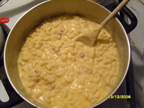 1989 Ford Bronco - A close-up shot shows a pot of macaroni and cheese with small pieces of ham mixed in. A wooden spoon is resting in the pot, and a date stam…