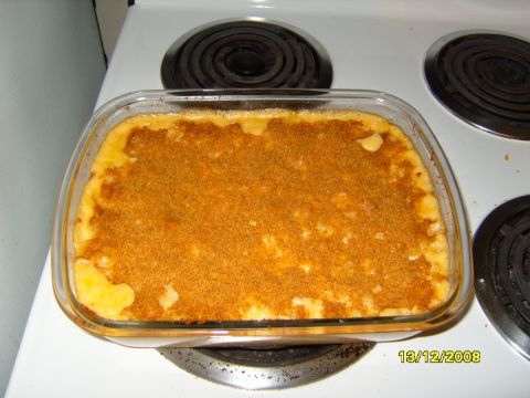 1989 Ford Bronco - A glass baking dish filled with macaroni and cheese topped with breadcrumbs sits on a white electric stovetop.