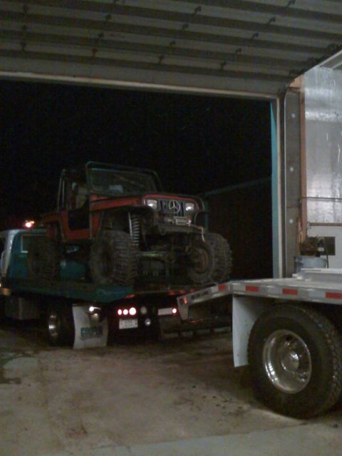 1992 Ford Bronco - Photograph of a Jeep on a flatbed tow truck, not a technical document.