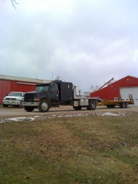 1992 Ford Bronco - Photograph of a flatbed truck and trailer outdoors, not a technical document.