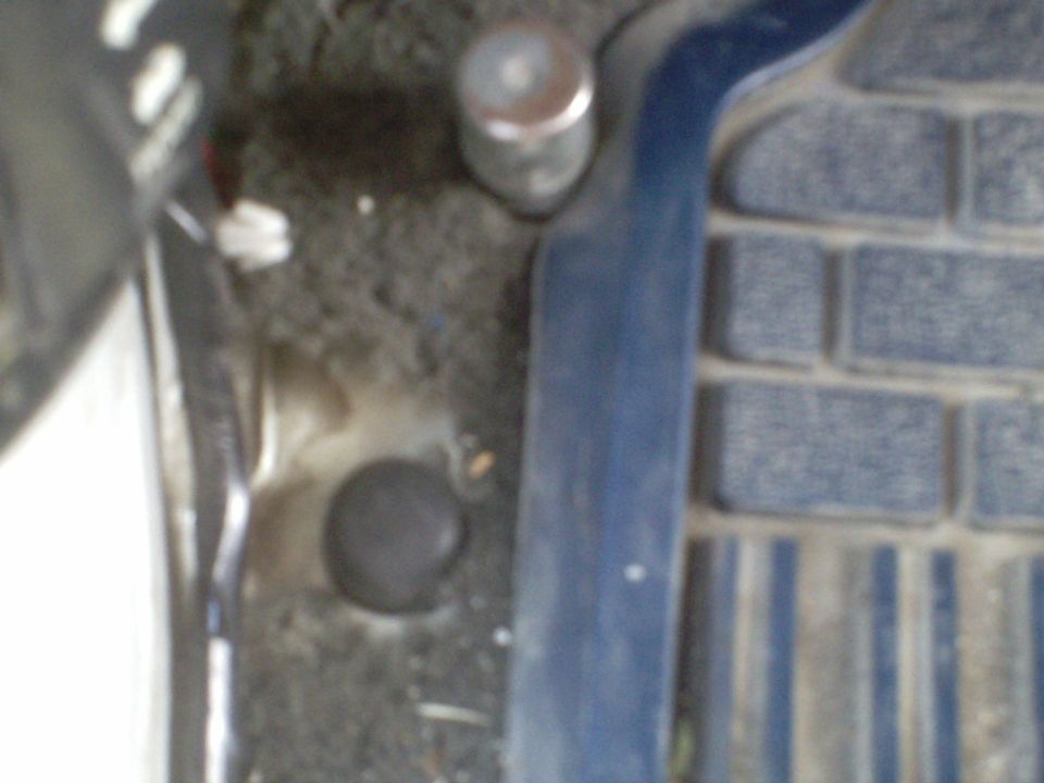 Interior vehicle floor with black cap, blue trim, and textured mat.