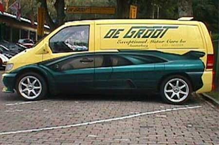 1999 Ford Taurus - A sports car is partially obscured by a yellow van with company text on its side.