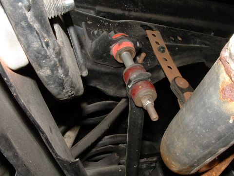 1978 Ford Ranchero - A close-up view of the undercarriage of a vehicle, focusing on the suspension system. Visible components include a sway bar link with red b…