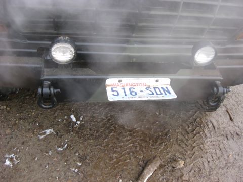 1989 Ford Bronco - The front bumper of a vehicle is shown with two round headlights and a Washington license plate reading "516-SDN". Towing shackles are visi…