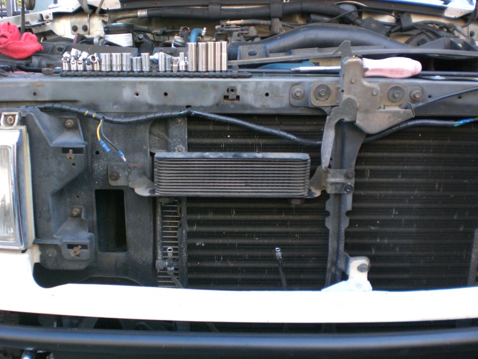 White Bronco front end with grille removed showing condenser and auxiliary cooler; sockets lined up on radiator support