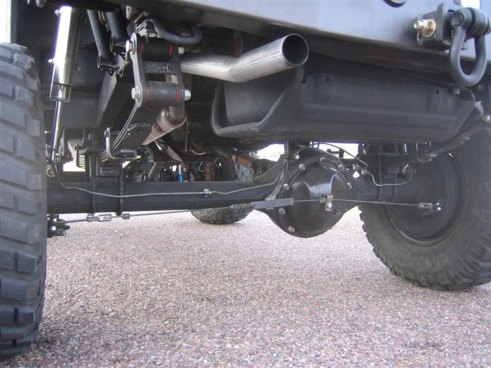Underbody view of lifted 4x4 rear axle, leaf springs, shocks and side-exit exhaust