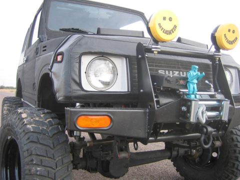 1987 Suzuki Samurai - A modified 1987 Suzuki Samurai is shown from the front, equipped with off-road tires and auxiliary lighting.