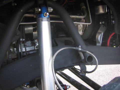 1987 Suzuki Samurai - Close-up view of the engine bay, highlighting a shock absorber and various hoses and mechanical components.