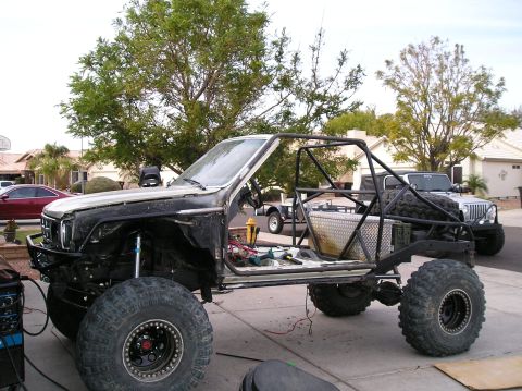 1986 Toyota Hilux - This heavily modified vehicle is undergoing a custom build, with a Jeep visible in the driveway.
