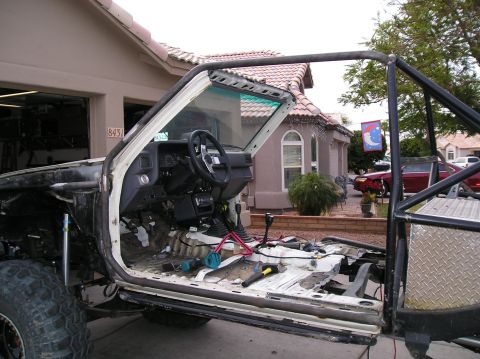 1986 Toyota Hilux - This heavily modified truck's interior shows extensive modifications, including a roll cage and stripped-down floor panels.