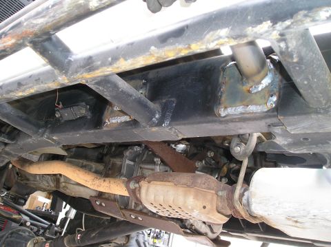 1986 Toyota Hilux - Custom roll cage and exhaust system installed on an off-road vehicle's undercarriage.