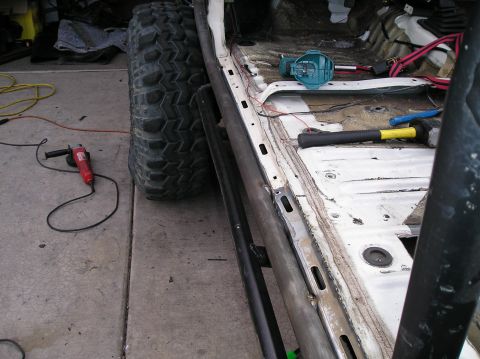 1986 Toyota Hilux - The interior of a vehicle is being modified, with tools and a large tire visible.
