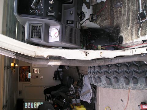 1986 Toyota Hilux - Interior view of a 1986 Toyota Hilux, revealing its dashboard, exposed wiring, and a large tire.