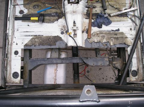 1986 Toyota Hilux - The interior floor of a vehicle is shown with tools and exposed metal, indicating disassembly or repair.