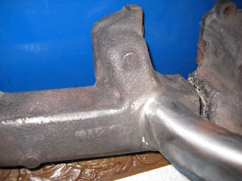 1953 Ford Mainline - Close-up of a damaged cast iron exhaust manifold with visible casting numbers.