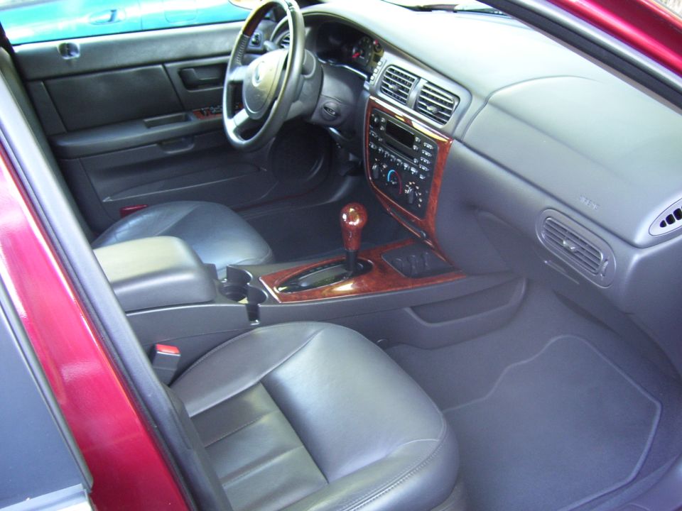 Gray and black car interior with wood trim, viewed from the passenger side