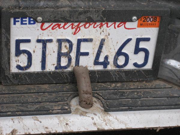 California license plate 5TBF465 with mud on it.