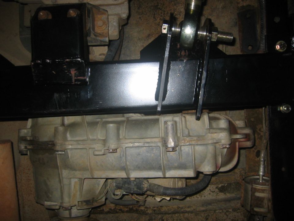 Transfer case under a black crossmember with heim joint linkage bracket bolted on