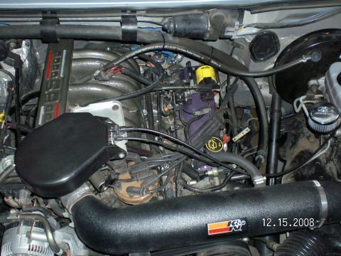 1996 Ford Bronco - The image shows a close-up view of the engine bay of a Ford Bronco, featuring a black K&N air intake system and various engine components.…