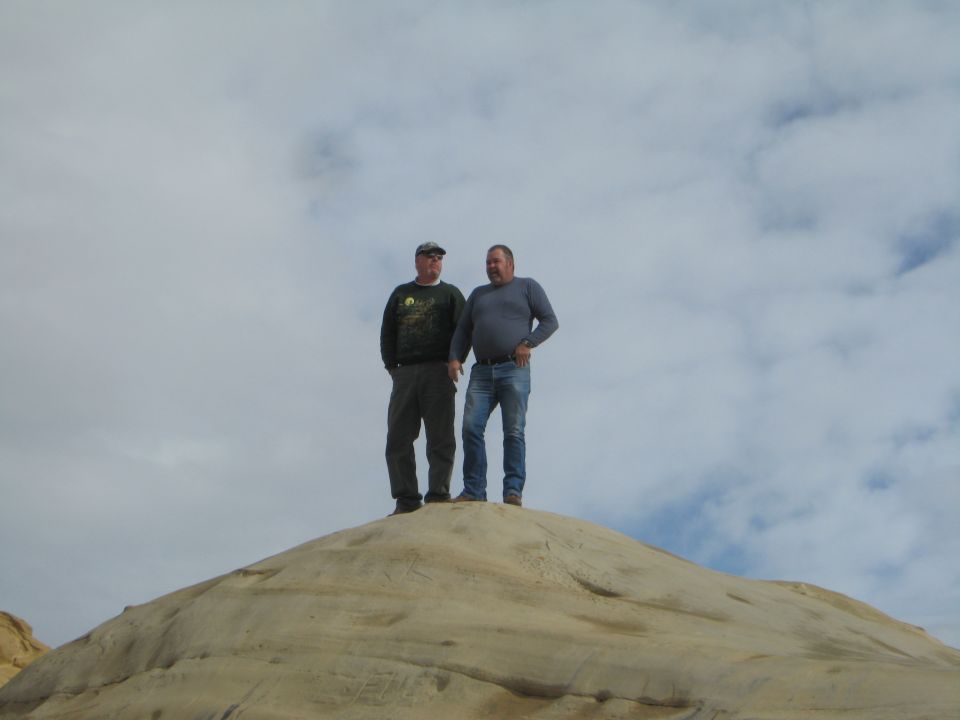 Two men standing on a rock formation.
