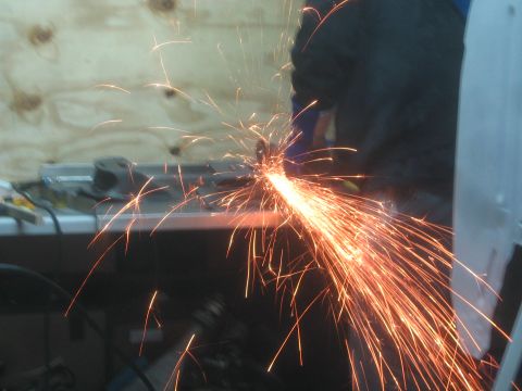 1990 Ford Bronco - Photograph of metal grinding or cutting producing a wide spray of sparks, not a document.