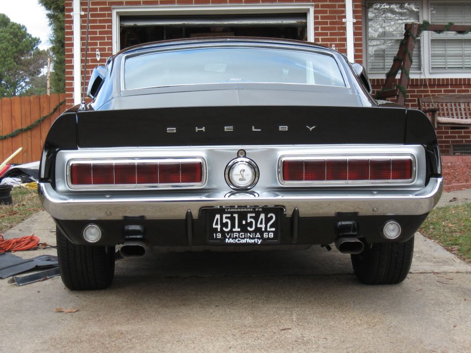 Rear view of a black 1968 Shelby GT500 with Shelby badging and chrome trim.