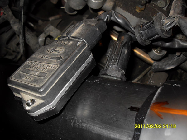 Ford mass air flow sensor on a black intake tube, with wiring.