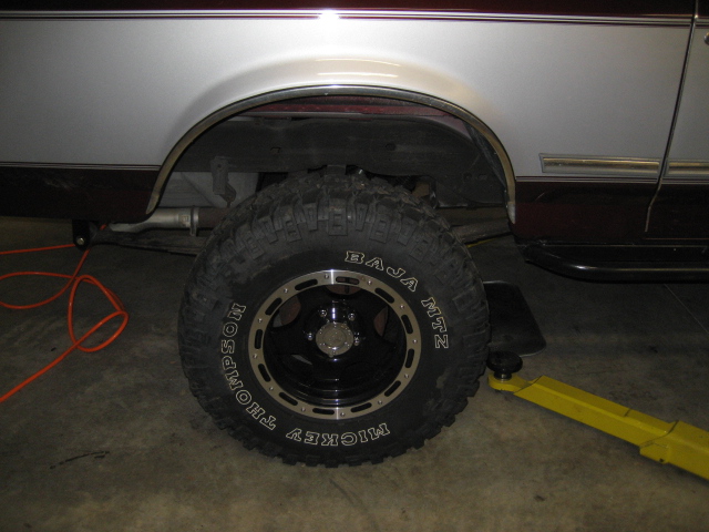 1996 Ford Bronco rear wheel and fender well with off-road tire.